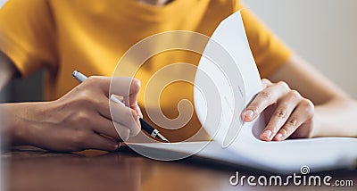 Woman signing document and hand holding pen putting signature at paper, order to authorize their rights. Stock Photo