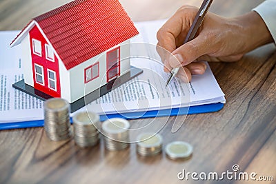 A woman signs a purchase agreement for a house in a real estate agent. Contract Buy - sell house concept Stock Photo