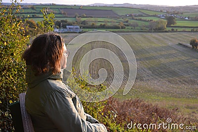 Woman sitting on a bench in autumn Stock Photo
