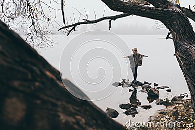 Woman silhouette on the river bank in the morning fog Stock Photo