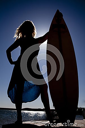 Woman silhouette stand by surfboard Stock Photo