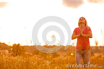 Woman silhouette waiting for summer sun on meadow Stock Photo