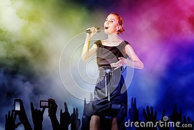 Woman singing for her fans on a concert Stock Photo