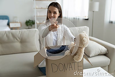 Woman prepared charity box with donated clothing and stuffed toy Stock Photo