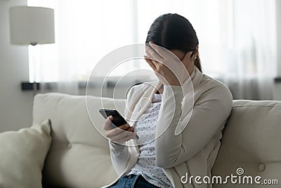 Stressed woman holding smartphone feels humiliated, cyberbullying concept Stock Photo