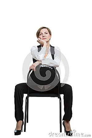 Woman sits astride a chair. hand under chin Stock Photo