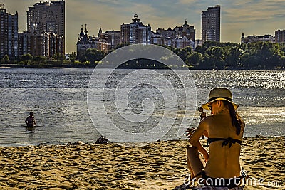 A woman sits on the beach Editorial Stock Photo