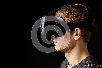 Woman Sits On Sofa At Home Wearing Virtual Reality Headset Stock Photo