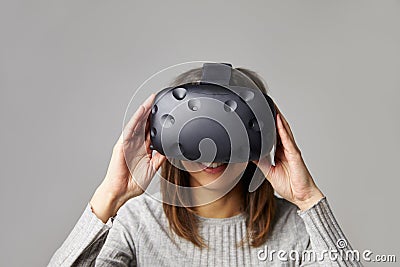 Woman Sits On Sofa At Home Wearing Virtual Reality Headset Stock Photo