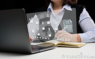 Woman sits at a table and works with a laptop. Document management mystem DMS. Software for automating archiving and efficient m Stock Photo