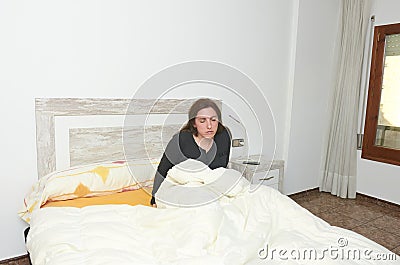 Woman sitting on bed. Tired woman doesn & x27;t want to get up. Stock Photo