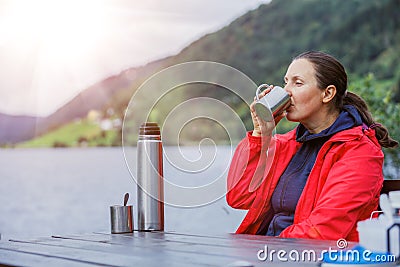 Woman sitting on the bench and enjoying the view on a fjord in Norway Stock Photo