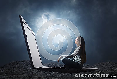 Woman is sitting on a big laptop Stock Photo