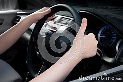 Woman sitting in a car seat and making a thumb up sign Stock Photo
