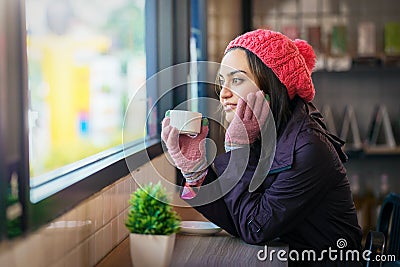 Woman sitting in coffee shop holding hot coffee cup in hands Stock Photo