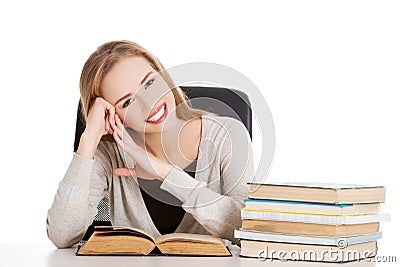 Woman sitting at the desk full of books Stock Photo