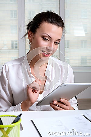 Woman sitting at a desk in an office is studying the information Stock Photo