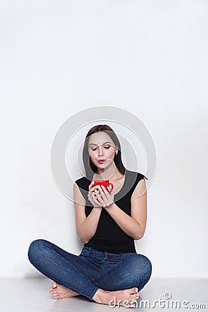 Woman sitting on floor with cup of tea or coffee Stock Photo