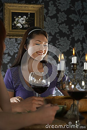 Woman Sitting With Friends At Dining Table Stock Photo