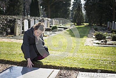 Woman sitting at grave Stock Photo