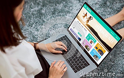 Woman sitting in her house with using laptop and booking flight travel search ticket holiday and hotel on website discounted price Stock Photo