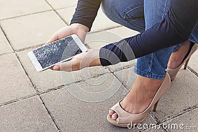 Woman is sitting and holding a broken smart phone Stock Photo
