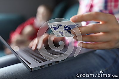 Woman sitting home sofa with laptop and credit card Stock Photo