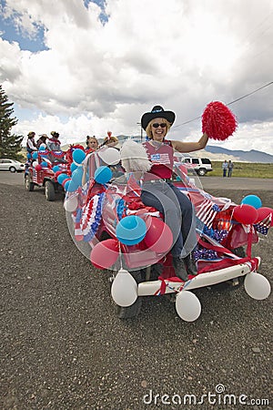 Woman sitting on the hood of a jeep decorated for the Fourth of July, in Lima Montana Editorial Stock Photo