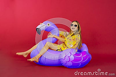 Woman sitting on inflatable flamingo in studio Stock Photo