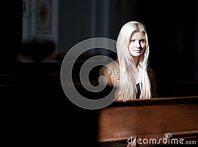 Woman sitting on a Pew Stock Photo