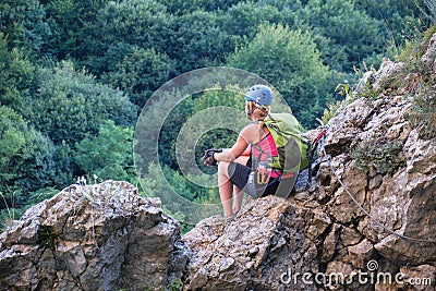 Woman sitting on rocks and admiring the view from Casa Zmeului via ferrata route in Padurea Craiului mountains, Romania. Stock Photo