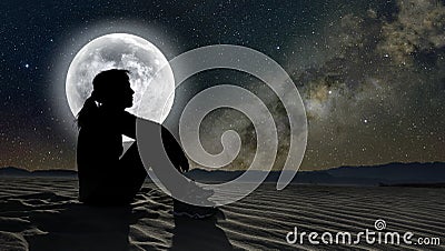 woman sitting on sand in the moonlight Stock Photo