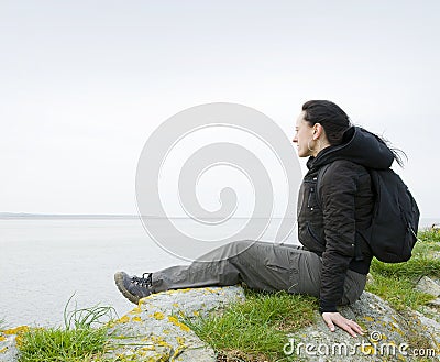 Woman sitting on sea cliff Stock Photo