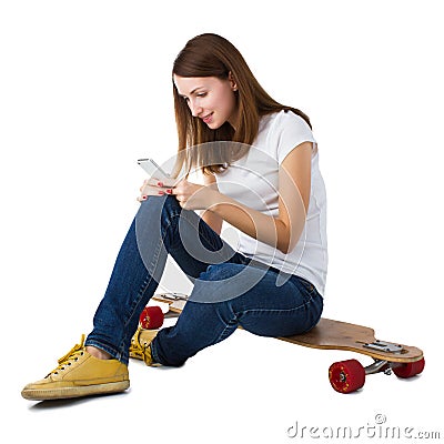 Woman sitting on skateboard and using smart phone Stock Photo