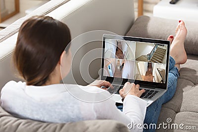 Woman Monitoring CCTV Footage On Laptop Stock Photo