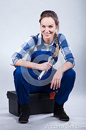 Woman sitting on toolbox Stock Photo