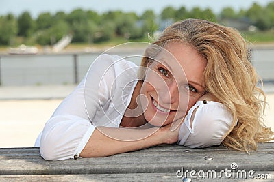 Woman sitting on the waterfront Stock Photo