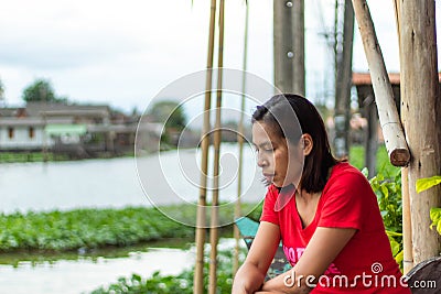 Woman sitting on wooden stairs water Stock Photo