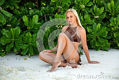 Woman sitting on the Zanzibar`s white sand beach Stock Photo