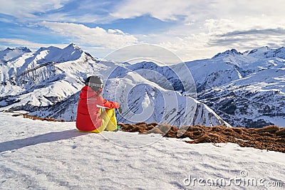 Woman skier looking at the mountain peaks in the French Alps, on Les Sybelles ski domain, above Saint-Jean-d`Arves village, France Stock Photo