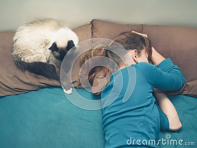 Woman sleeping in bed with cat Stock Photo