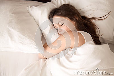 Woman sleeping in bed hugging soft white pillow Stock Photo