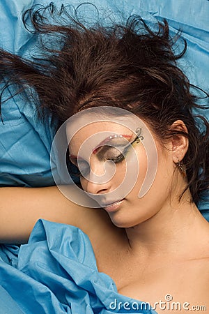 Woman sleeping in blue bedclothes Stock Photo