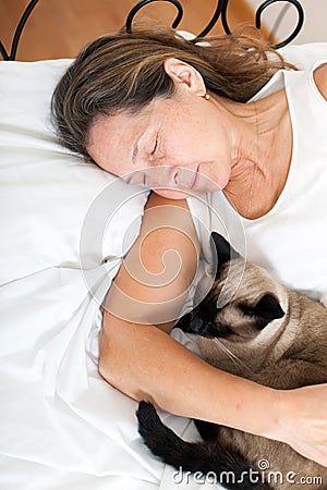 Woman sleeping in embrace with cat Stock Photo