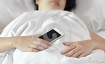 Woman sleeping and holding a mobile phone. Stock Photo