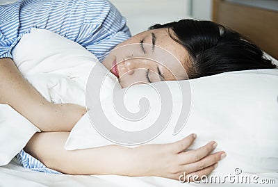 A woman sleeping peacefully on bed Stock Photo