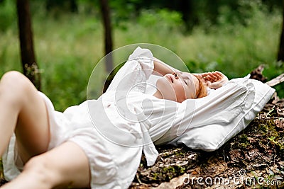 A woman sleeps in the woods on a pillow. Healthy, sound sleep concept. Rest, relaxation in nature Stock Photo