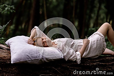 A woman sleeps in the woods on a pillow. Healthy, sound sleep concept. Rest, relaxation in nature Stock Photo