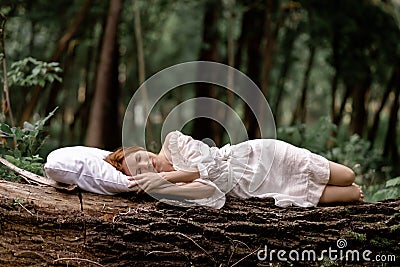 A woman sleeps in the woods on a pillow. Healthy, sound sleep concept. Rest, relaxation in nature Stock Photo