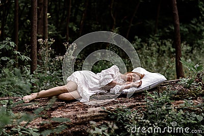 A woman sleeps in the woods on a pillow. Healthy, sound sleep concept. Rest, relaxation in nature Stock Photo